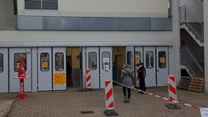 Der Weg zur Corona-Teststelle am Ludwigsburger Krankenhaus (rechts) ist sehr gut ausgeschildert.  Zu sehen ist eine Testperson auf dem Weg in das Krankenhausgebäude. Die Tests finden direkt hinter den Türen statt.⇥