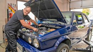 Peter Hilcher kontrolliert die Motoreinstellungen eines VW Golf 1 Cabrios.
