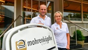 Jörg und Monika Adamek, die Inhaber des Café Mohrenköpfle, vor ihrem Laden im Ludwigsburger Stadtteil Eglosheim. Ihr Logo zeigt den Namensgeber: das Biskuit-Gebäck „Mohrenköpfle“.