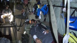 Sanitätsstabsoffizier und Notarzt  Dr. Michael Lutz-Dettinger (stehend)  behandelt einen afghanischen Patienten in einem Rettungshubschrauber im Pamir-Gebirge nahe der afghanisch-chinesischen Grenze. 