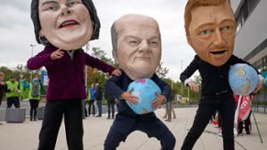 Umweltschützer, maskiert als Politiker, haben vor Kurzem vor dem Kongresszentrum in Berlin protestiert.⇥