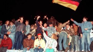 Mit Wunderkerzen in den Händen freuen sich die Menschen auf der Berliner Mauer im November 1989 über die Öffnung der deutsch-deutschen Grenzen. Foto: dpa